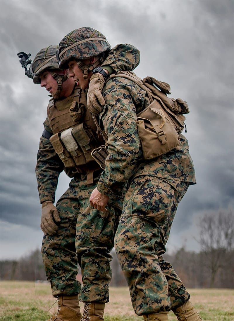 Two Marines during a field exercise under a heavy sky